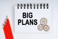 On a white background, there are red pencils, gears and a notebook with the inscription - BIG PLANS Royalty Free Stock Photo