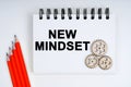 On a white background, there are red pencils, gears and a notebook with the inscription - NEW MINDSET Royalty Free Stock Photo