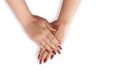 On a white background, a woman shows her manicured hands with red glitter nail polish.Concept of a beauty salon