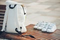 White backpack, sneakers on wooden bench