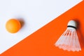 White badminton shuttlecock and orange ball for table tennis on an orange-white background. Royalty Free Stock Photo