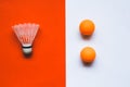 White badminton shuttlecock and orange ball for table tennis on an orange-white background. Royalty Free Stock Photo