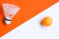 White badminton shuttlecock and orange ball for table tennis on an orange-white background. Royalty Free Stock Photo