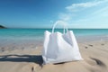 A white bag with handles stands on the beach on the sand Royalty Free Stock Photo