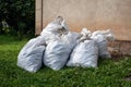 White bags with construction debris and garbage bu the wall of teh house. Cleaning and sorting Royalty Free Stock Photo