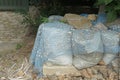 White bags of sand and cement covered with blue plastic mesh Royalty Free Stock Photo