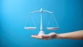 White balance scale held on open hand against blue background justice weighing Royalty Free Stock Photo
