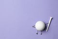 White ball as golf player on lilac background - creative image Royalty Free Stock Photo