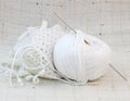 White ball (clew) of yarn and knitting hook