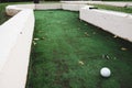 White ball at golf course with distance to target hole. Playing mini golf on artificial green grass outdoors. Setting goals and Royalty Free Stock Photo