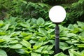 White ball lantern on an iron pole of ground garden lighting.