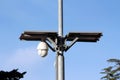 White ball shaped rotatable waterproof security camera CCTV powered by two small solar panels on top mounted on metal utility pole