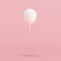 White balloon floating on pink background