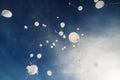 White balloons fly up into the blue sky. The release of festive balloons in the clouds. Air gel balls in the atmosphere Royalty Free Stock Photo