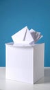 White ballot box with multiple envelopes on a white table against a bright blue background Royalty Free Stock Photo