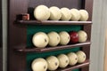 white balls and one brown ball on the shelf-stand for billiard balls in a row for playing Russian Billiards. fun game and sport