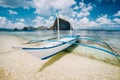 White banca boat on the sandy beach ready for island hopping trip. Amazing Pinagbuyutan island in background. Beautiful Royalty Free Stock Photo