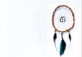 Round handmade Dreamcatcher made of willow branches and green, black feathers,  on a pure white background Royalty Free Stock Photo