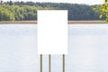 A white banner stands on the lake shore with a mockup