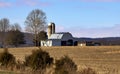 White Barn with Metal Roof and Silo in Winter Corn Field Royalty Free Stock Photo