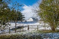 A White Barn on a Midwest Farm in Winter Framed by a Fence and Trees Royalty Free Stock Photo