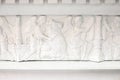 White bas-relief on frieze with angels and sacred cows closeup. Classic elements of facade decoration, ancient architecture. Front