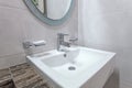 white basins in bathroom interior with granitic tiles