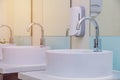 white basins in bathroom interior with granitic tiles