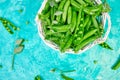 White Basket with fresh green peas on blue background Royalty Free Stock Photo