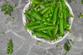 White Basket with fresh green peas on grey background. Royalty Free Stock Photo