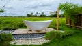 white bath tub outside on vacation at a homestay in Thailand with green rice paddy field Royalty Free Stock Photo