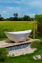 white bath tub outside on vacation at a homestay in Thailand with green rice paddy field Royalty Free Stock Photo