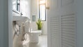 White bathroom door that overlooks the sink and toilet lit by the window