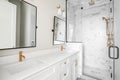 White bathroom with gold hardware and the lights off. Royalty Free Stock Photo