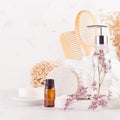 White bathroom interior with natural bamboo accessories and beauty products - essential oil in amber glass, towel, sponge. Royalty Free Stock Photo