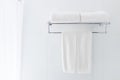 White bathroom towels hanging on the rack in a white bathroom ne Royalty Free Stock Photo