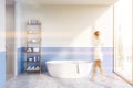 White bathroom with tub and shelves, woman