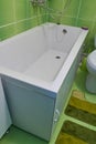 White bathtub in the bathroom,square bath in the middle of the room with green tiles