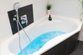 White bathtub with the light blue bathwater