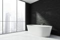 White bathtub in the panoramic bathroom interior with black wall. Corner view Royalty Free Stock Photo