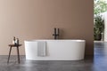 A white bathtub standing on a concrete platform with beige wall background.
