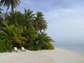 2 white beach chairs on sand beach of tropical island Royalty Free Stock Photo