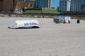 White beach sand with Atlantic City rescue boat turned upside down. There are two young teen girls sitting on the sand Royalty Free Stock Photo