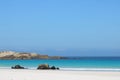 Idylic beach scene with rocks and sea towards the horizon Royalty Free Stock Photo