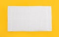 White beach towel on yellow background, top view Royalty Free Stock Photo