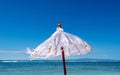 White beach umbrella against blue sea and sky Royalty Free Stock Photo