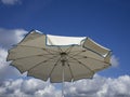 White beach umbrella . Blue sky with white clouds background