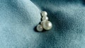 White beads lie on a velvet blue fabric. Jewelry on the curtains. A beautiful combination of mother-of-pearl shine and light tints