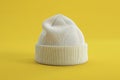 Of a white beanie on a yellow background, in a minimalist style, with high resolution Royalty Free Stock Photo
