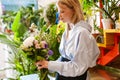 White beautiful florist girl holding bouquet with flowers in shop Royalty Free Stock Photo